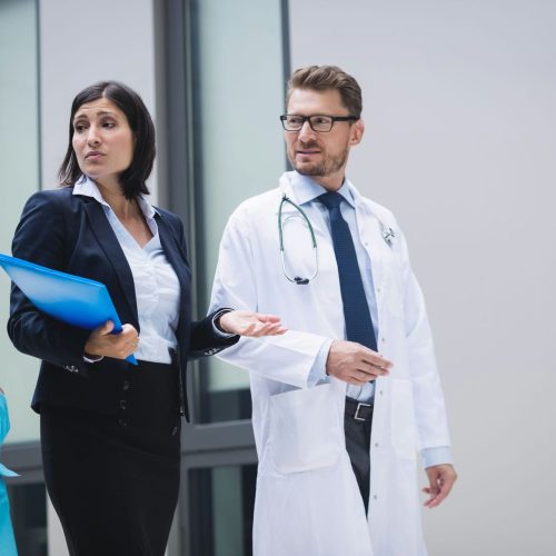 Doctors and nurse interacting while walking in hospital premises